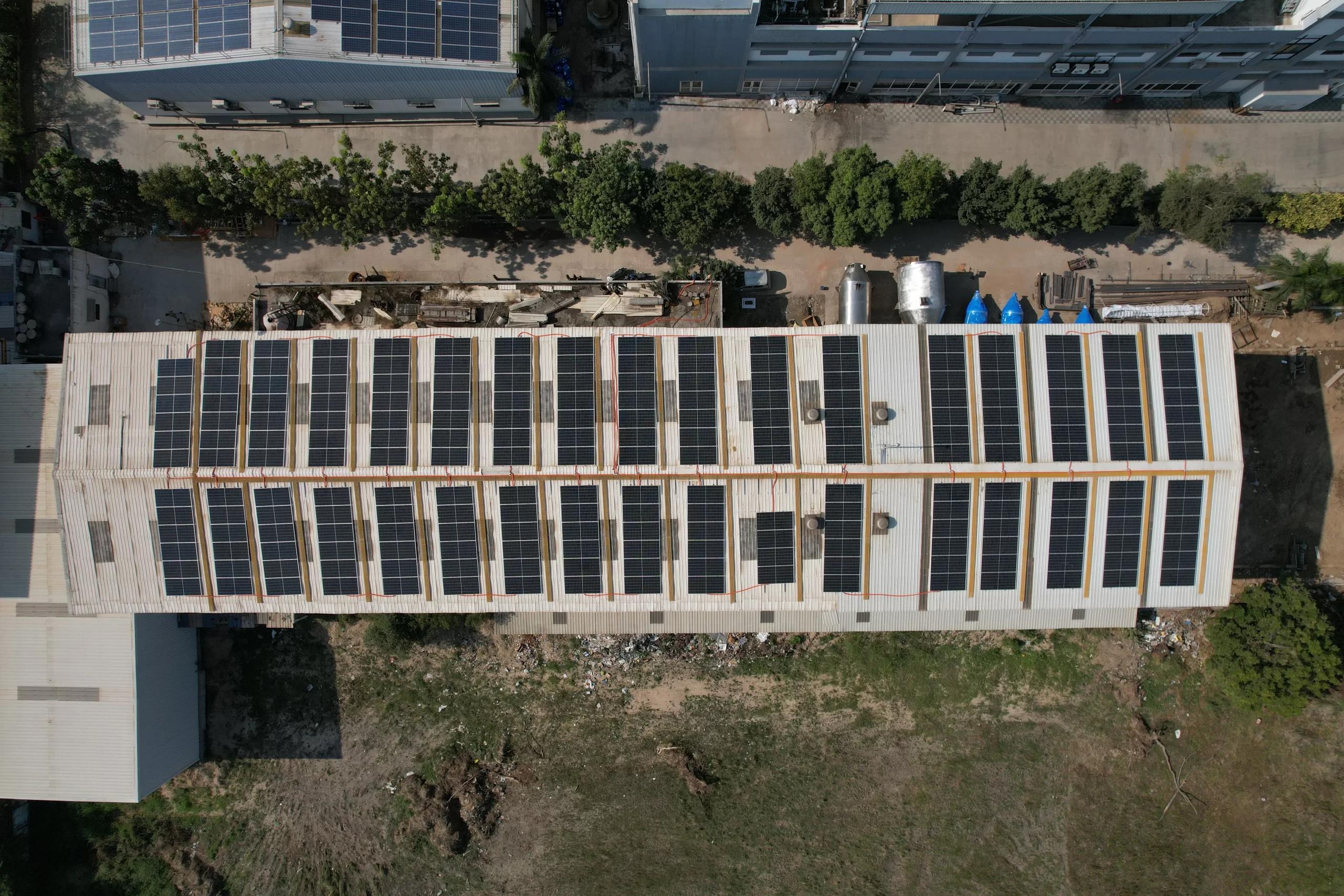 Aerial view of an industrial rooftop fully covered with solar panels