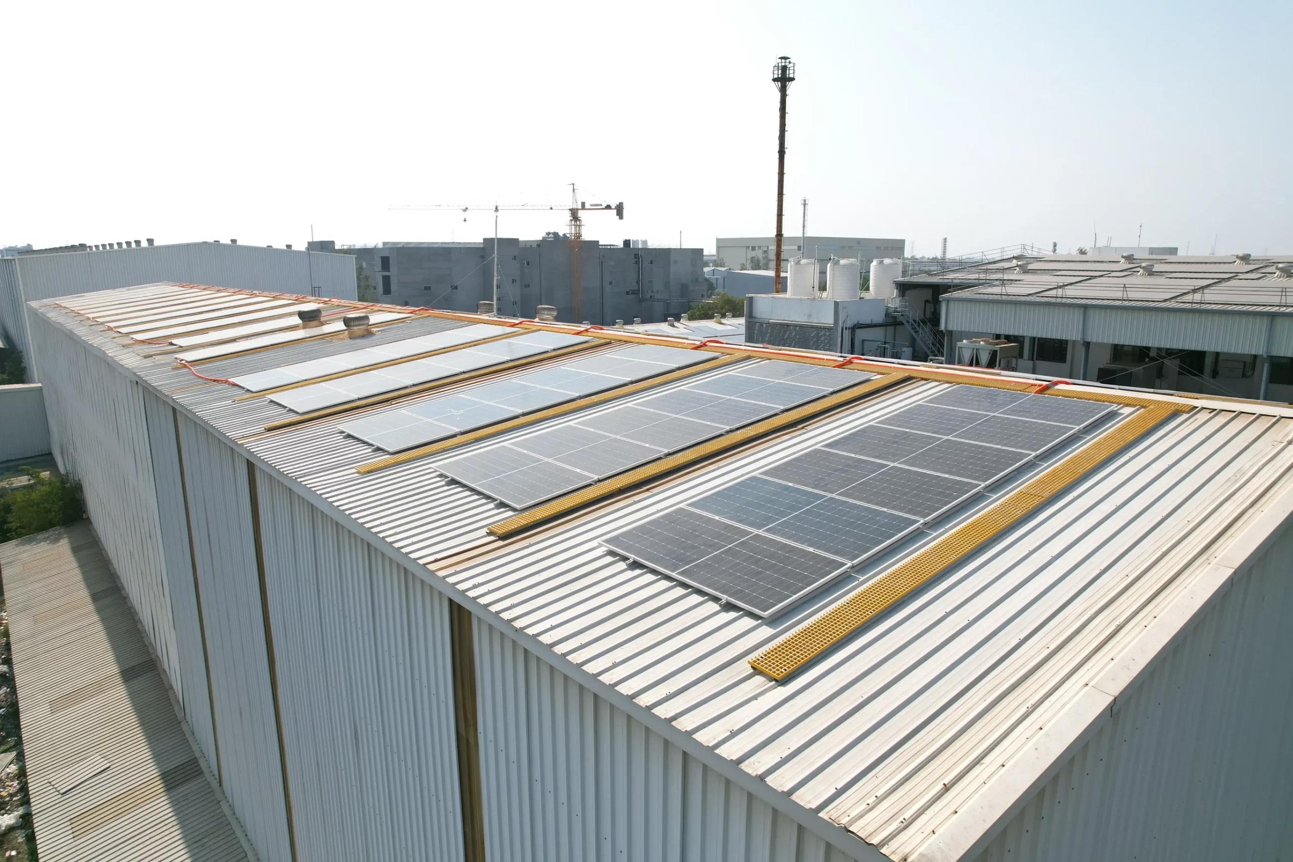 Close aerial view of solar panels on a corrugated industrial roof